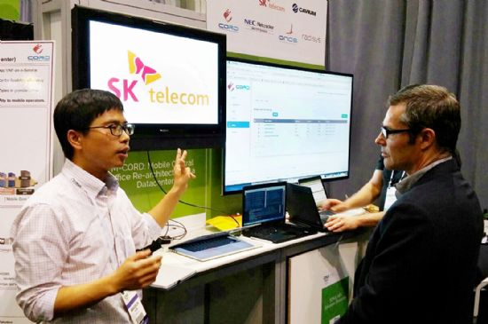 SK텔레콤 윤민근 매니저(왼쪽)가 지난 주말 미국 산타클라라에서 열린 ONS(Open Networking Summit) 2016에 참가, AT&T의 가상화 네트워크 아키텍트인 톰 토파이에게 M-CORD 플랫폼을 시연하고 있다.