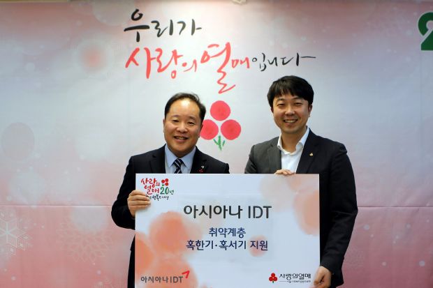 남궁용 아시아나IDT 경영지원팀장(왼쪽)이 천상영 서울 사랑의열매 모금사업팀 과장에게 모금액을 전달하고 있다.