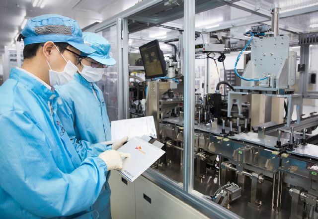 SK이노베이션 서산공장 전기차 배터리 생산라인에서 직원들이 생산된 배터리 셀을 살펴보고 있다.(사진=SK이노베이션)