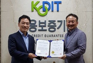 이인수 신용보증기금 서울서부스타트업지점장(왼쪽)이 김현영 마켓디자이너스 대표에게 퍼스트 펭귄 기업 인증서를주고 있다.