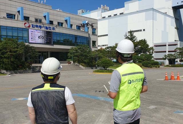 한국동서발전 당진화력본부 내 건축물 및 설비 고층부 안전점검을 시행하기 위해 직원들이 드론을 조종하고 있다.
