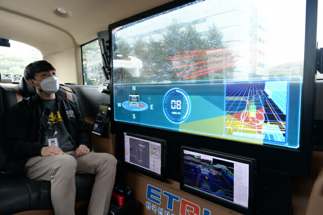 - ETRI 연구진이 개발한 자율주행 셔틀버스 '오토비' 내 투명 OLED 디스플레이로 AR 실감 가이드 기술을 시연하고 있다.