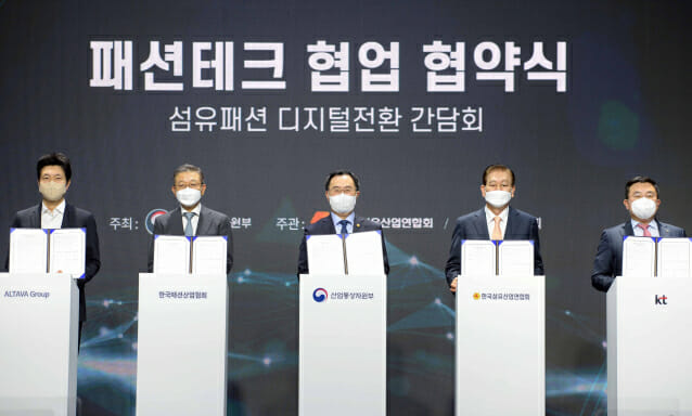 문승욱 산업부 장관(가운데)이 한국섬유산업연합회, 한국패션산업협회, IT업체 관계자들과 패션테크 협력을 위한 협약을 체결한 후 협약서를 들어보이고 있다.