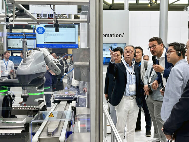 ‘오토매티카 2023’을 참관한 박지원 두산그룹 부회장(왼쪽)이 한 로봇업체 부스에서 회사 관계자에게 제품에 대해 질문하고 있다. (사진=두산)