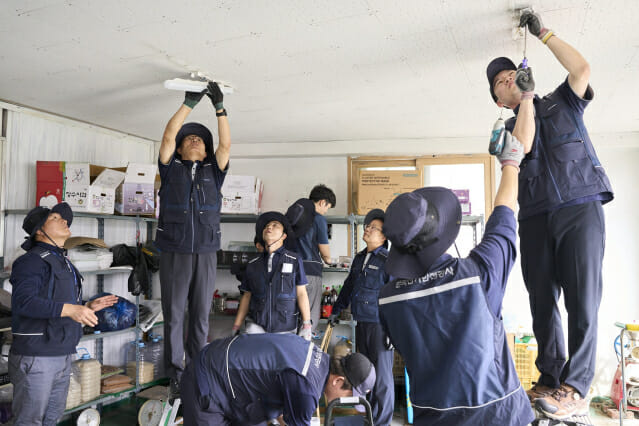 박지현 전기안전공사 사장(왼쪽 두 번째)이 직원들과 함께 LED 등기구를 교체하고 있다.