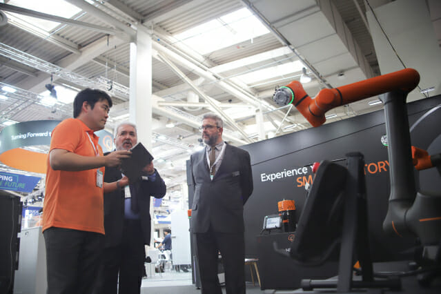 EMO 2023 한화 전시관에 방문한 관람객들이 당사 개발자로부터 협동로봇 신제품 HCR-14에 대한 설명을 듣고 있다. (사진=한화 모멘텀)