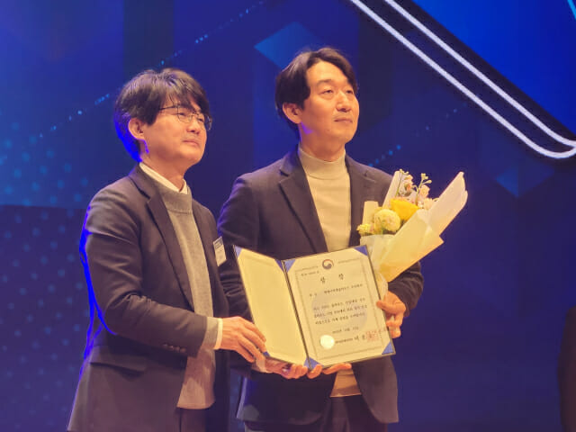 김도훈 NHN클라우드 대표(오른쪽)가 엄열 과기정통부 인공지능정책관에게서 상을 받고 있다.