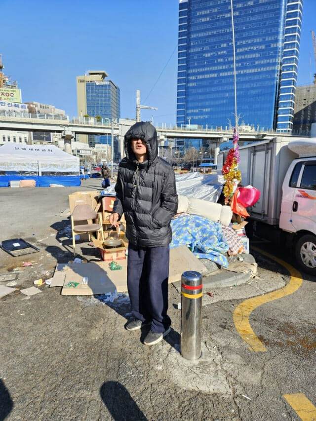 [서울=뉴시스] 오정우 기자 = 22일 오후 1시께 한 노숙인이 서울역 앞에 추위에 떨고 있다. 2023.12.22. penlyn173@newsis.com