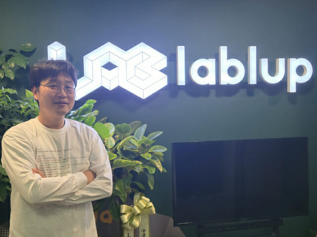 신정류 래블업 대표가 회사 CI를 배경으로 포즈를 취했다.