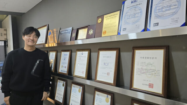 신호철 대표가 회사가 받은 인증을 배경으로 포즈를 취했다.