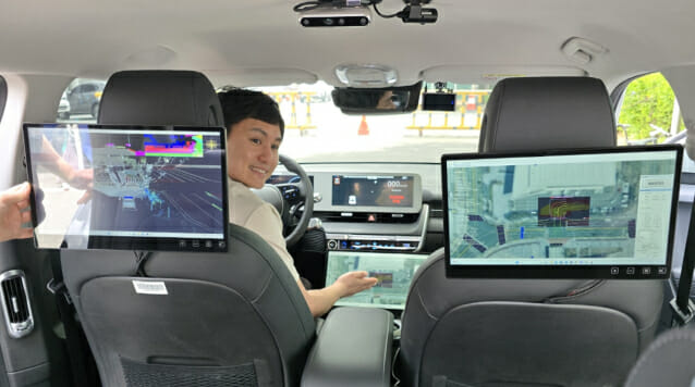 ETRI가 선보인 아이오닉 자율주행차량 내부. ETRI 연구원이 기능을 설명 중이다.