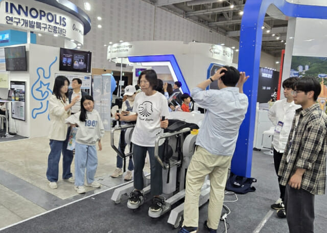 관람객이 팔과 다리 움직임으로 장비를 조작하는 모습.