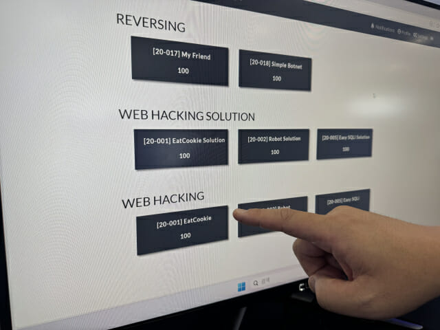 기자가 풀어야 하는 문제를 가리키고 있는 대회 관계자.