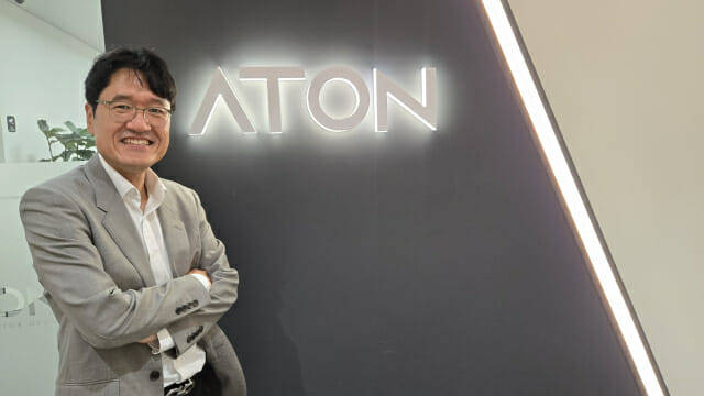 우길수 아톤 대표가 회사CI를 배경으로 포즈를 취했다.