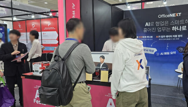 관람객이 'AI페스타 2025' 지란지교소프트 부스에서 설명을 듣고 있다.