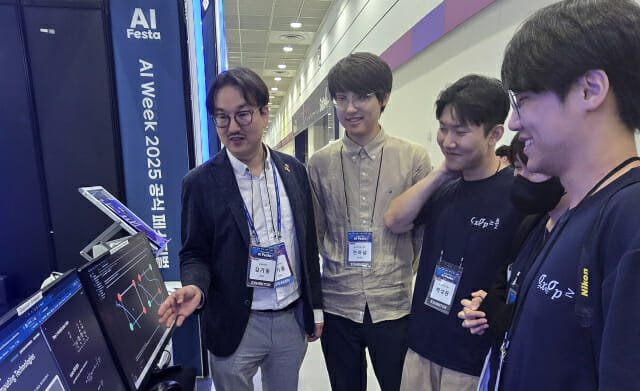 최근 열린 AI페스타 양자기술관에 부스를 차린 김기웅 충북양자연구센터장이 제자들에게 양자역할 이론에 대해 설명했다.