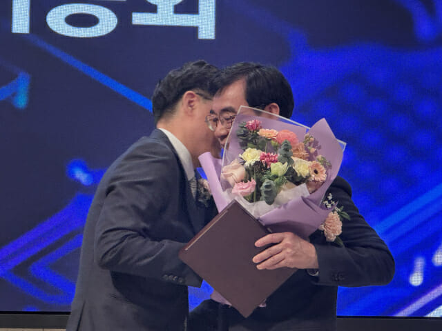 취임식을 마친 김진수 KISIA 신임 회장(왼쪽)과 조영철 KISIA 회장이 서로 포옹하고 있다.