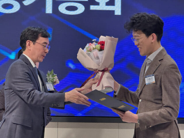 구동언 로그프레소 전무가 조영철 KISIA 전 회장으로부터 상장과 꽃다발을 받고 있다.