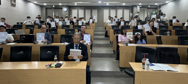 하계 공동 학술 대회 참석자들이 학술대회 책자를 들어 보이고 있다.